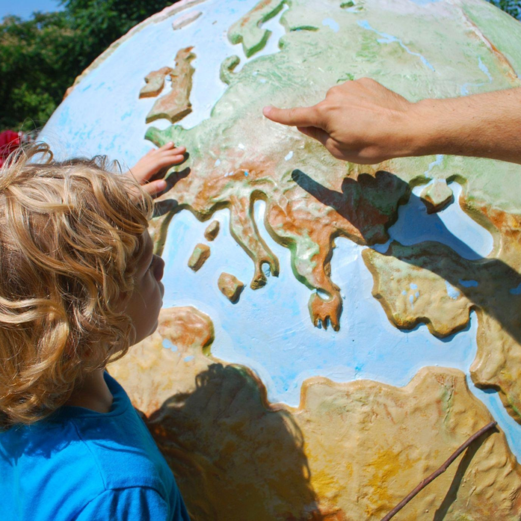 Child looking at a globe and learning during vacation.