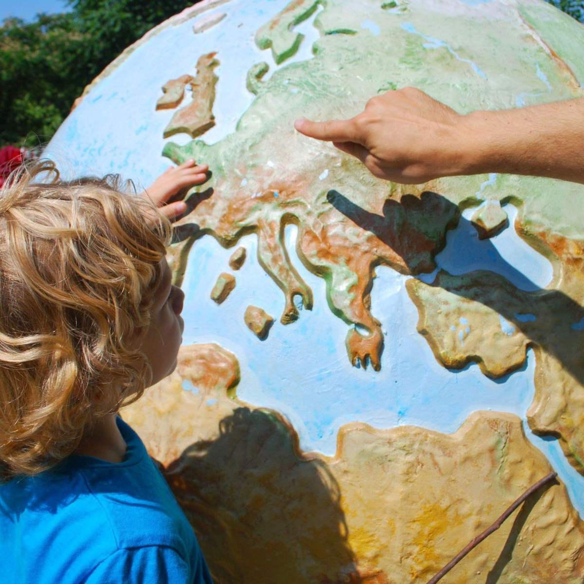 Child looking at a globe and learning during vacation.