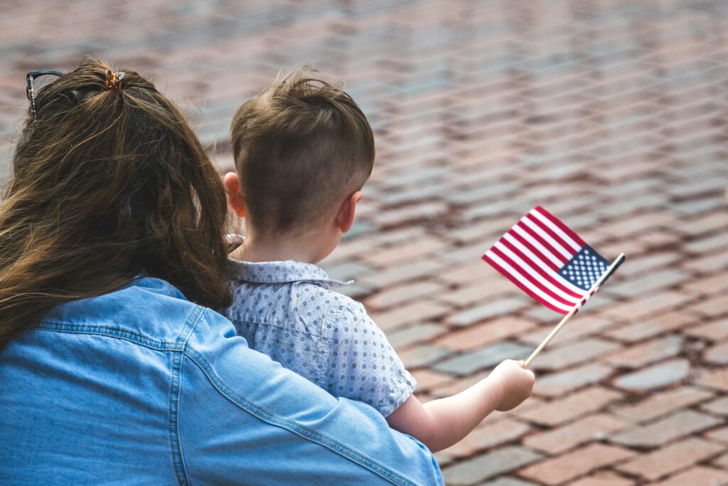 Child and mom holding American flag on Veterans Day