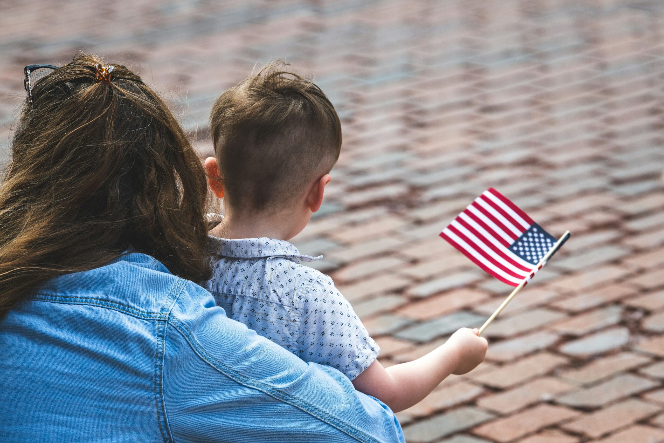 Child and mom holding American flag on Veterans Day