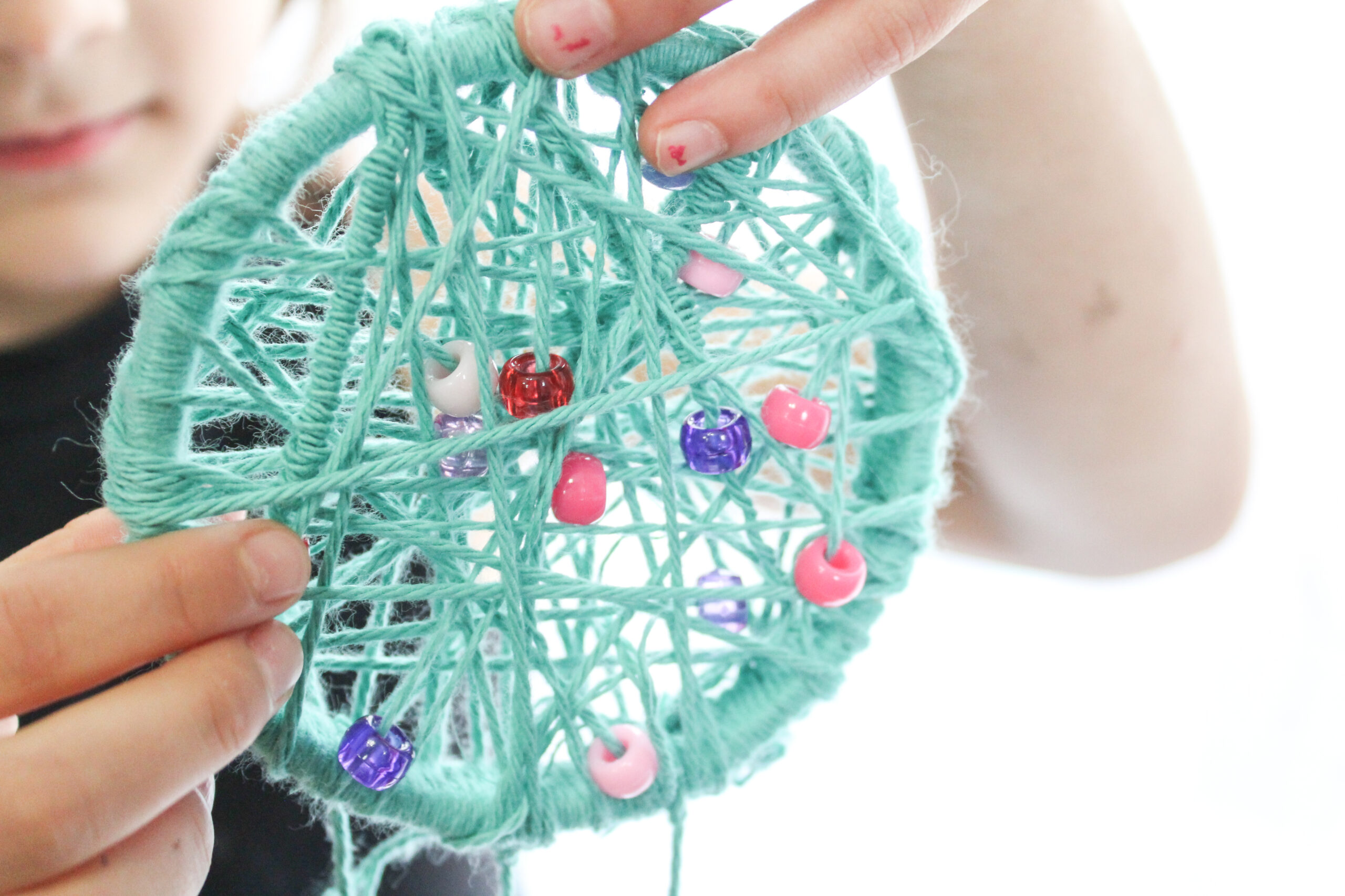 child holding finished dreamcatcher