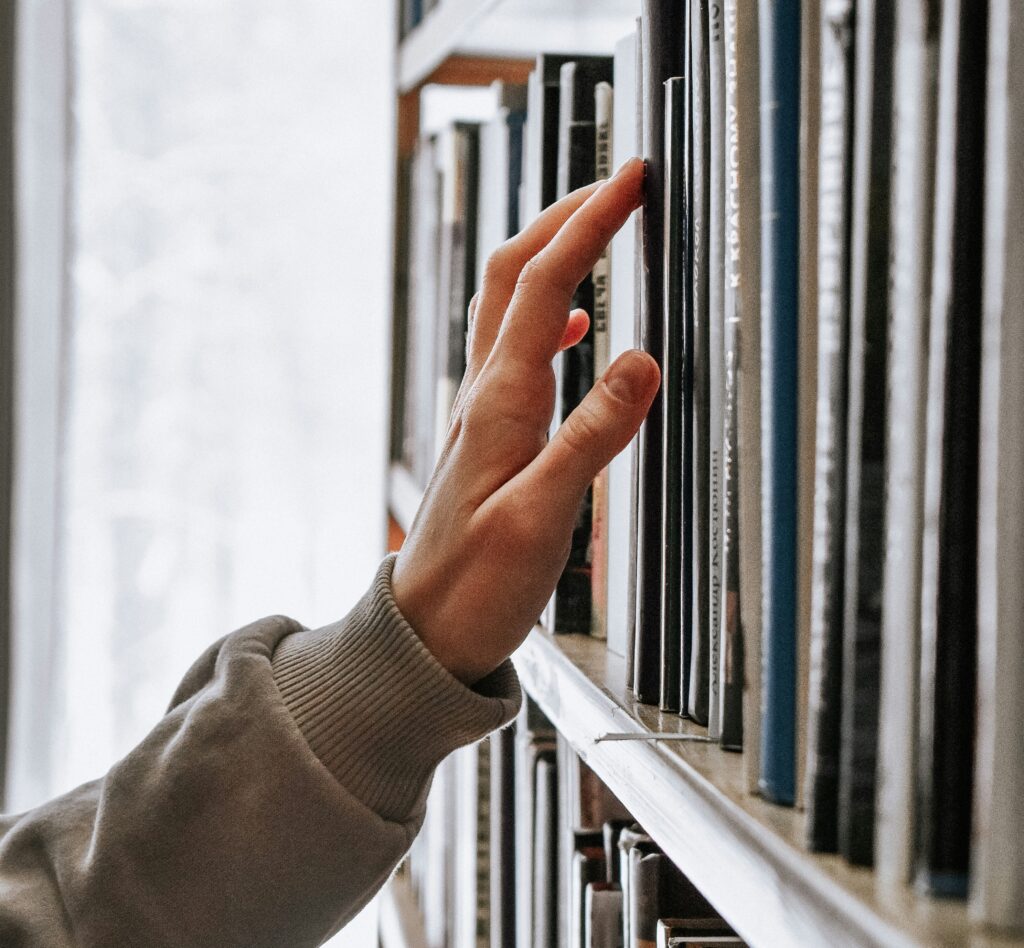 child touching books in the library