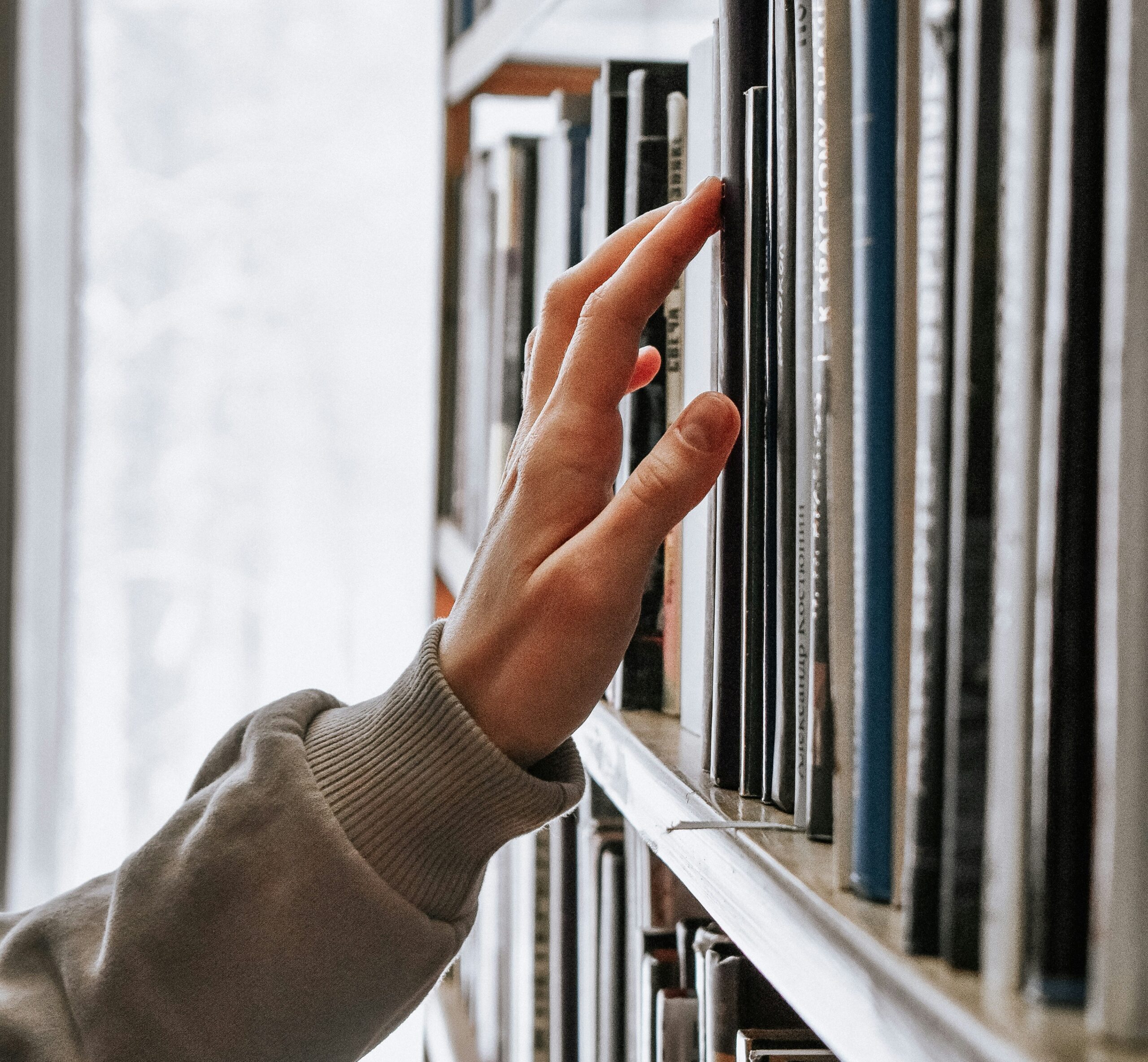 child touching books in the library