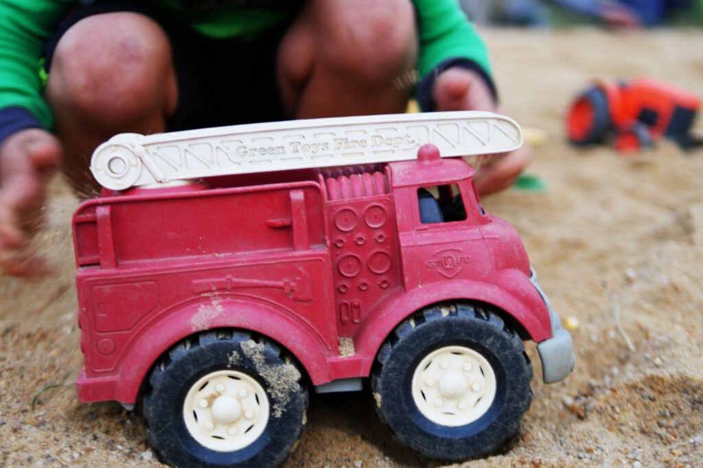 child playing with a toy firetruck